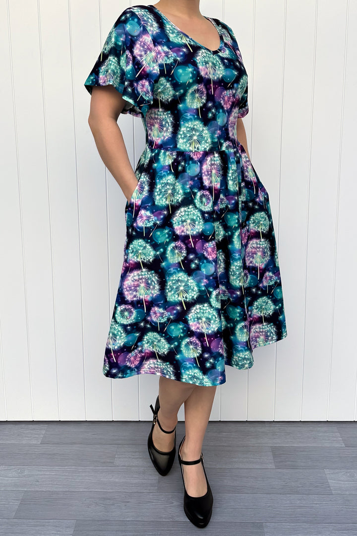 Woman wearing a colorful floral dress with a white background