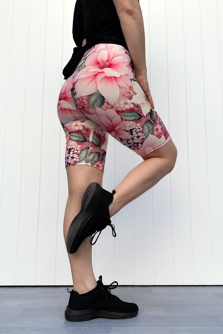 Person wearing pink and cream floral shorts standing in front of white background