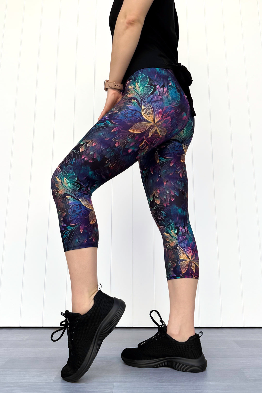Person wearing floral-patterned leggings with a white background