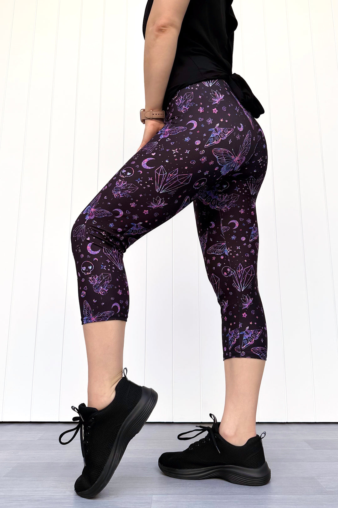 Person wearing purple capri leggings with celestial design against a white background