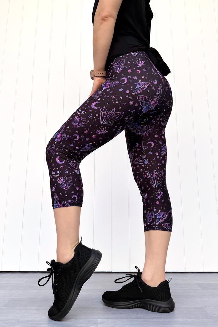 Person wearing purple capri leggings with celestial design against a white background