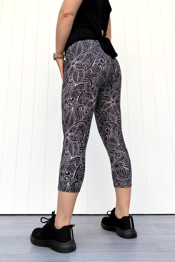 Person wearing black and white patterned leggings with a plain background