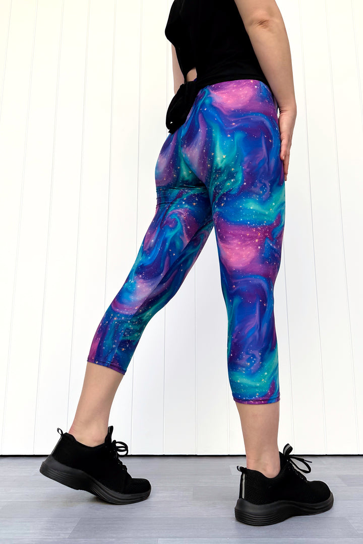 Person wearing galaxy-themed leggings with a white wall background