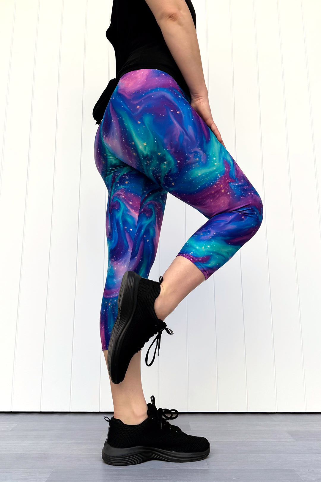 Person wearing galaxy-themed leggings with a white background