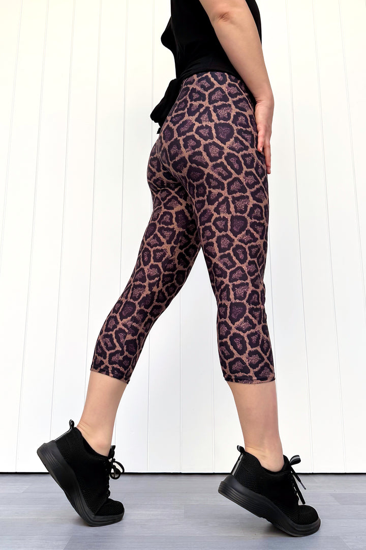 Person wearing leopard print leggings with a plain background