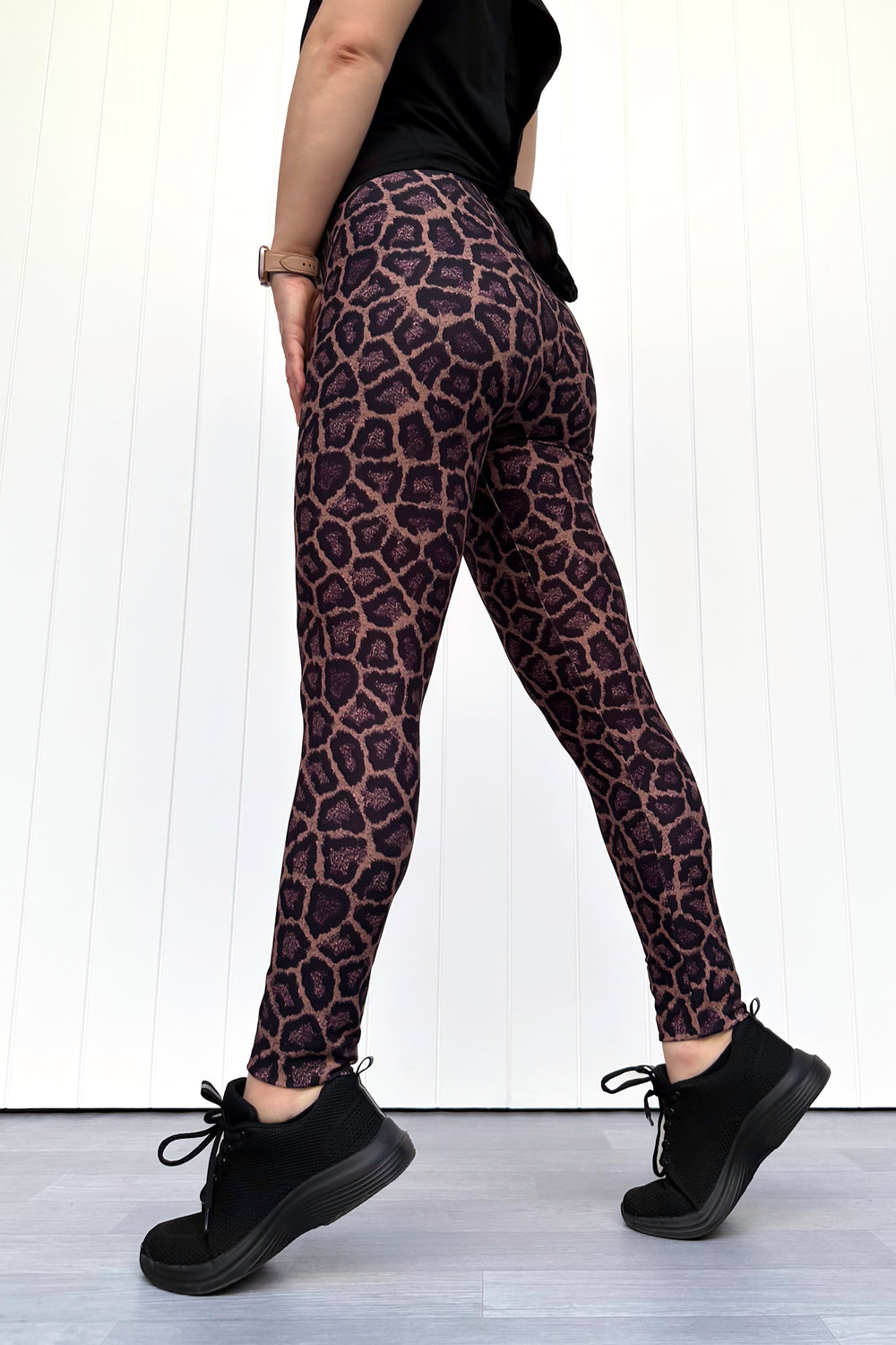 Person wearing leopard print leggings with a plain background