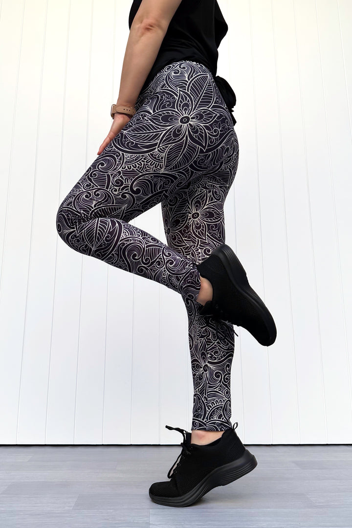 Person wearing black and white patterned leggings against a white background