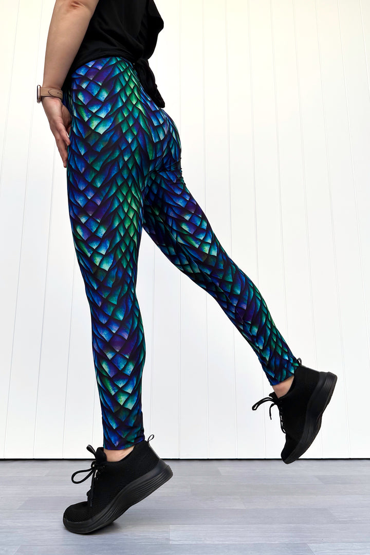 Person wearing dragon scale pattern leggings on a white background