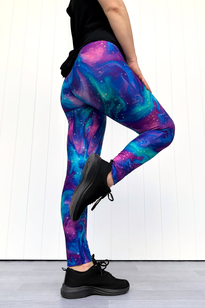 Person wearing galaxy-themed leggings with a white background